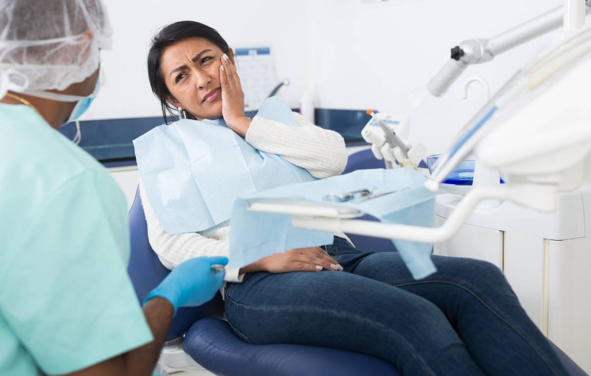Patient talking to dentist and complaining of toothache at dental clinic office.